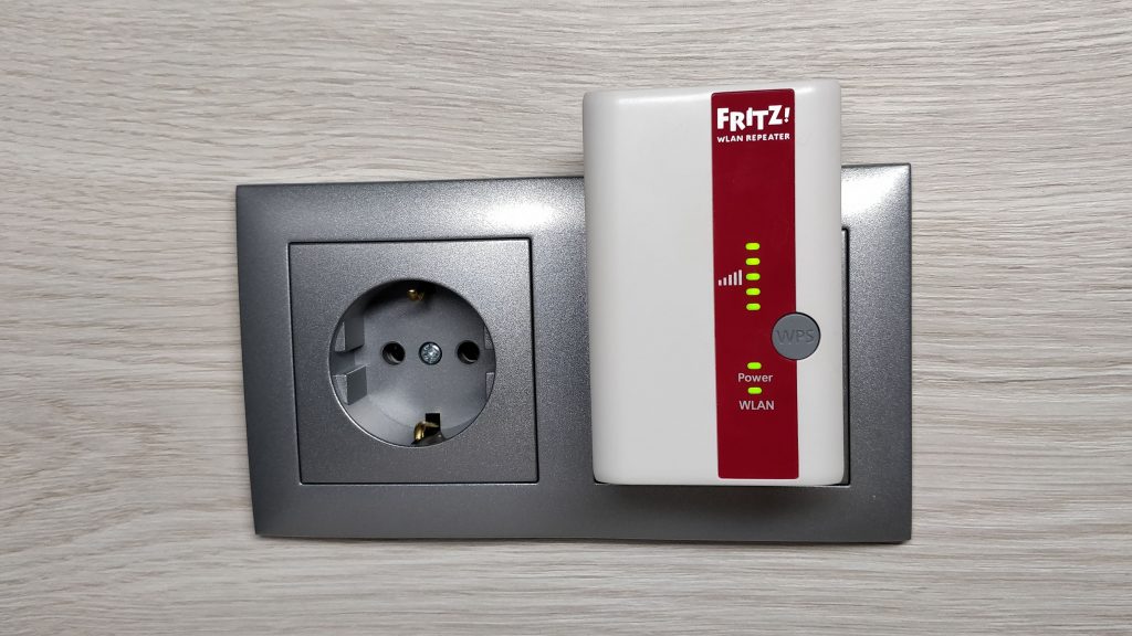 Der FRITZ!Repeater 310 steckt in einer silbernen Steckdose, alle LEDs leuchten auf