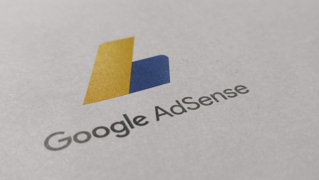 Das gelb-blaue Google AdSense-Logo auf weißem Papier